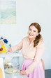 © LIGHTFIELD STUDIOS - smiling beautiful woman pouring milk into bowl with flour at kitchen