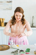 © LIGHTFIELD STUDIOS - beautiful woman adding egg to flour for dough at kitchen