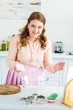 © LIGHTFIELD STUDIOS - smiling beautiful woman holding bowl with flour in kitchen