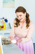 © LIGHTFIELD STUDIOS - happy beautiful woman holding bowl with flour in kitchen