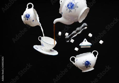 Fotografía Flying porcelain coffee set - ghost tea party on black background