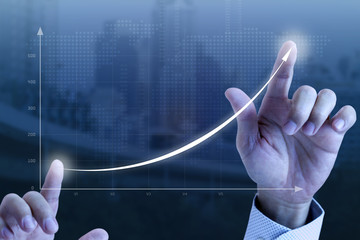 close up of a businessman’s hands drawing an exponential line curve showing of business growth and s