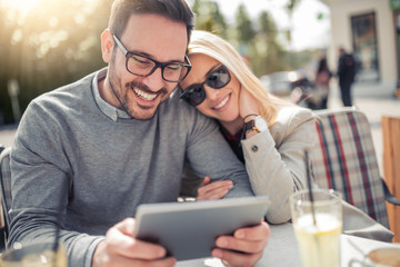 Sticker - Happy couple at coffee shop looking at tablet