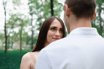 Nice outdorr portrait of young beautiful couple in love with green background