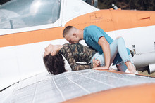 Couple makes love on wing of old plane on sunny day. Couple in love full of desire have sex near airplane on background. Couple on excursion to museum of aviation in open air. Passion concept.