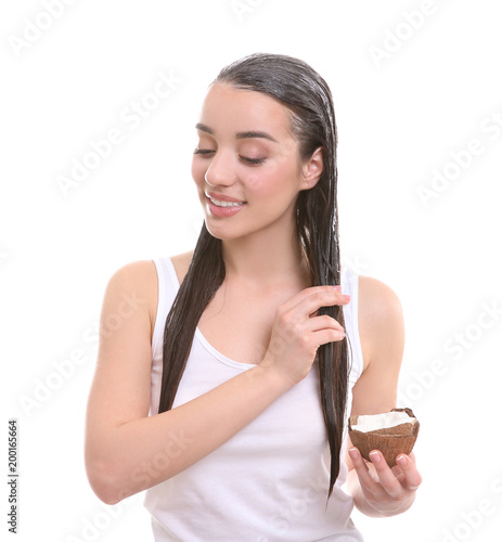 Young Woman Applying Coconut Oil Onto Hair Against White