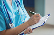 © Wavebreak Media - Mid section of nurse writing on clipboard
