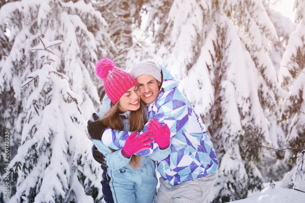 Happy couple at snowy countryside. Winter vacation