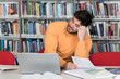 © Jale Ibrak - Tired Student Working With Laptop in the Library