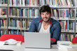 © Jale Ibrak - Happy Male Student With Laptop in Library