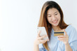 © mangpor2004 - Young asian woman holding credit card and using smart phone for shopping online, business and technology concept, online payment, digital money