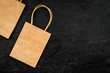 © 9dreamstudio - Brown kraft paper bag for shopping on black background top view mockup copy space