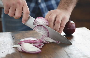 Canvas Print - Close up male hands chopped fresh red onion wooden table