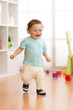 © Oksana Kuzmina - First steps of baby toddler learning to walk in living room. Footwear for little children.