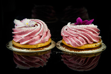 two pink zephyr cookies on black background