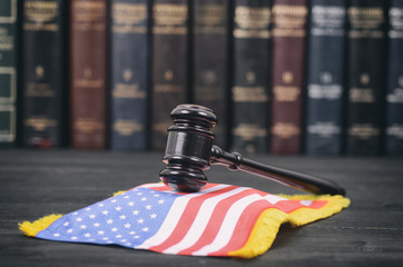 Wall Mural - Judge Gavel and United States of America flag on a black wooden background.