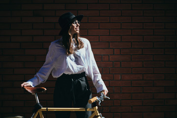 Wall Mural - Portrait of beautiful brunette posing with her yellow fixie bicycle.