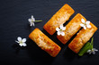 Food concept mini French almond cake financier on black slate stone with copy space