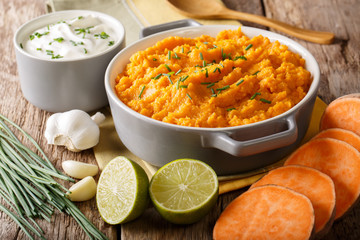 Wall Mural - Freshly prepared mashed sweet potatoes with herbs, garlic and lime close up in a pot. horizontal