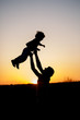 © Ольга Тернавская - Silhouette of a man and his son playing together outdoor at sunset. Vertical photo. Family concept