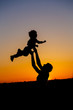 © Ольга Тернавская - Loving father and his little son having fan together outdoors. Happy family. Fatherhood. Toddler boy and his dad playing. Family as silhouette on sunset. Vertical photo