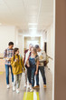 © LIGHTFIELD STUDIOS - group of multiethnic high school classmates walking by school corridor together