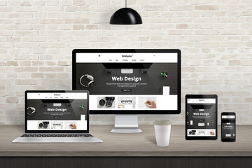 Responsive web site presentation on diferent display devices. Modern studio interior. Brick wall in background.