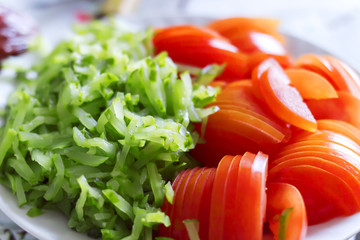 sliced tomatoes and cucumbers lie on a plate, close-up