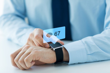 business, technology and people concept - close up of male hands wearing smart watch with social media icons