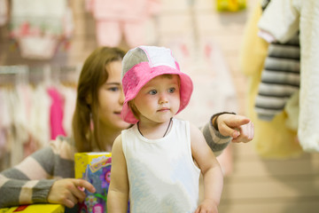 Young mother and her little daughter in the hat during shopping