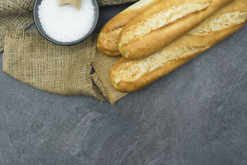 French baguette on a wooden dark table with sackcloth.