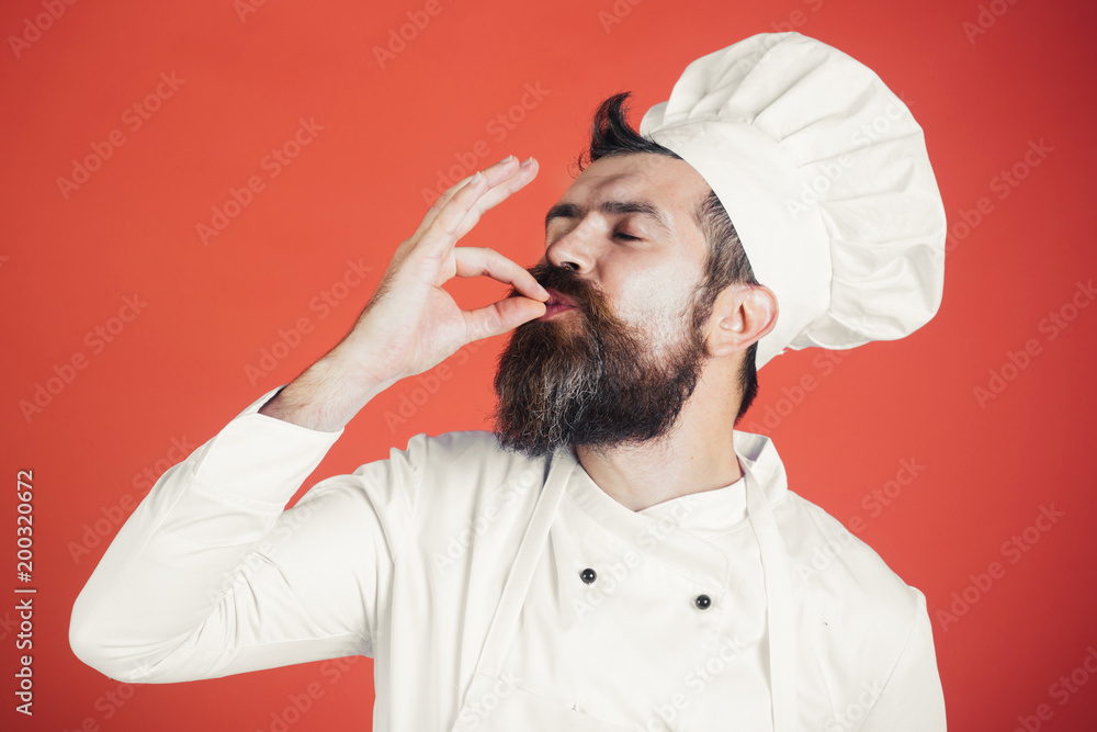 Professional chef man showing sign for delicious. Male chef in white uniform with perfect sign. Serious satisfied bearded chef, cook or baker gesturing excellent. Cook with taste approval gesture. - obrazy, fototapety, plakaty 