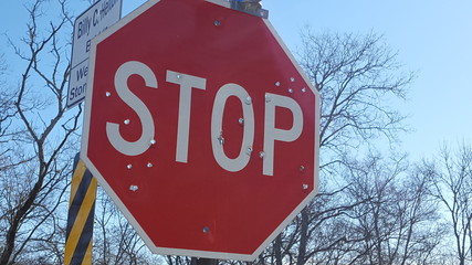 Stop sign with bullet holes.