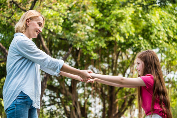 Wall Mural - Mother and daughter having fun together in a park. Family and lifestyle concept