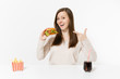© ViDi Studio - Beautiful young woman sitting at table with burger, french fries, cola in glass bottle isolated on white background. Proper nutrition or American classic fast food. Advertising area with copy space.