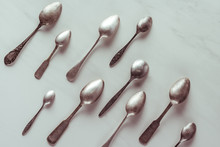 Various Vintage Spoons On White Table