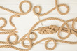 top view of empty paper on brown nautical knotted ropes on white wooden surface