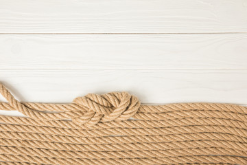 Sticker - top view of brown nautical ropes placed in row on white wooden background