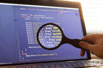 PHP back-end code zoomed through a magnifier. Computer programming source code lookup. Abstract screen of web developer. Code is created by myself.