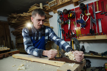 the carpenter scribbles the wooden beam in the woodworking workshop in Castres.