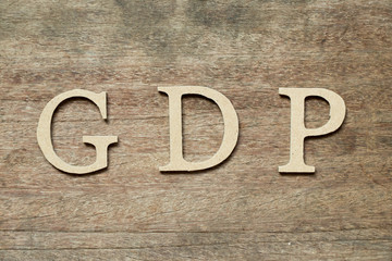 Poster - English alphabet in word GDP (Abbreviation of good distribution practice or gross domestic product) on wood background