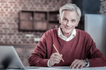 Wall Mural - Favorite work. Senior cheerful male engineer staring at camera while holding pencil and smiling