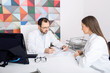 © Peakstock - Two doctors sitting in the clinic office and sign documents