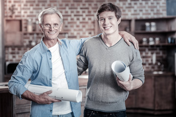 Wall Mural - Reach your goals. Merry jovial male engineers grinning while embracing and looking at camera