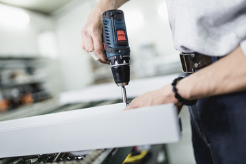 Wall Mural - Manual worker assembling PVC doors and windows. Manufacturing jobs. Selective focus. Factory for aluminum and PVC windows and doors production.