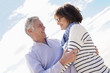 © goodluz - Portrait of senior couple embracing by the beach