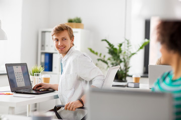 Wall Mural - business and people concept - happy creative workers with laptop computers working at office