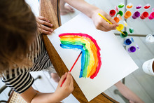 Children Painting A Rainbow On Paper