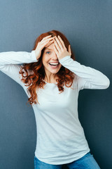 Wall Mural - Laughing vivacious woman covering one eye