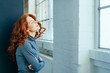 © contrastwerkstatt - Young redhead woman standing daydreaming